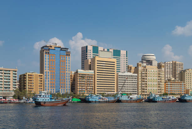 Skyscrapers and traditional boats along Dubai Creek symbolize the modern and historic aspects of Dubai property.